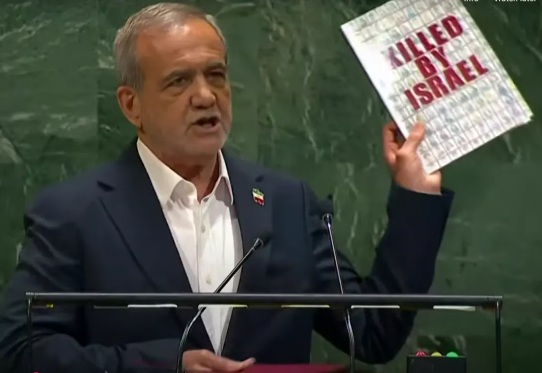 Image shows Iranian President Mas’ud Pezeshkian at his 2025 UN speech holding a brochure with the text ‘Killed by Israelis,’ intended to amplify narrative impact.